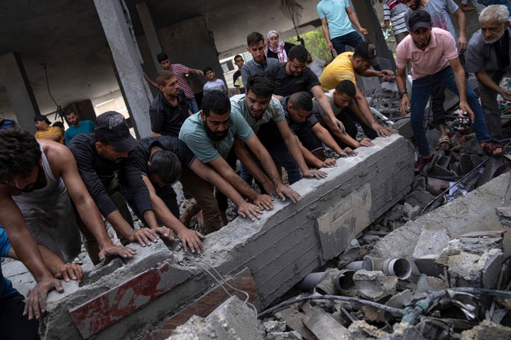 Palestinians look for survivors in a building destroyed in Israeli bombardment in Rafah refugee camp in Gaza Strip on Tuesday, Oct. 17, 2023. (AP Photo/Fatima Shbair)