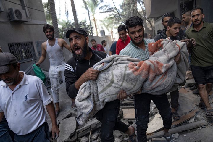 Palestinians evacuate wounded from a building destroyed in Israeli bombardment in Rafah refugee camp in Gaza Strip on Tuesday, Oct. 17, 2023. (AP Photo/Fatima Shbair)