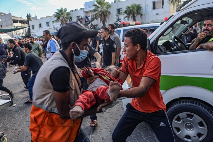イスラエル軍の空爆で怪我をしたパレスチナの子どもをアル・シファ病院に搬送する人々（2023年10月17日）
