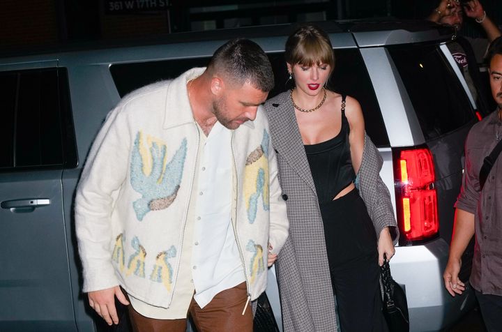 Travis Kelce grabbing Taylor Swift’s hand after he helped her out of the car.