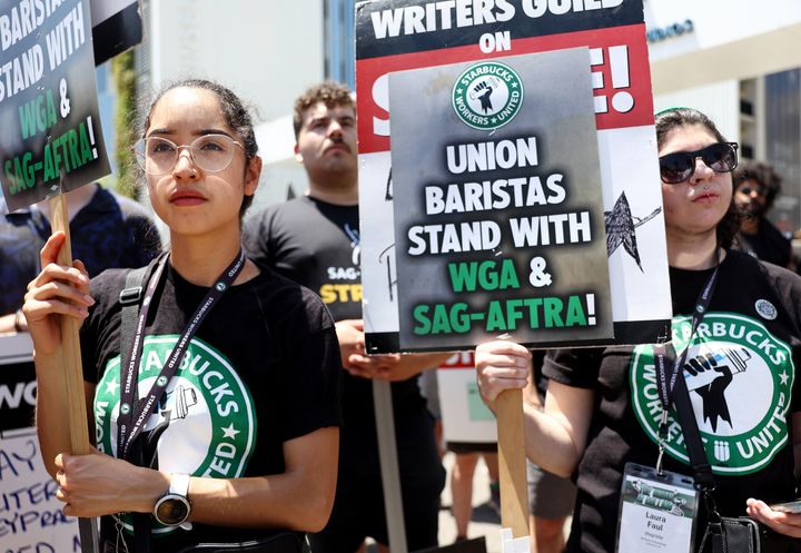Starbucks workers, seen here picketing in solidarity with striking writers and actors, have unionized more than 350 stores since 2021.