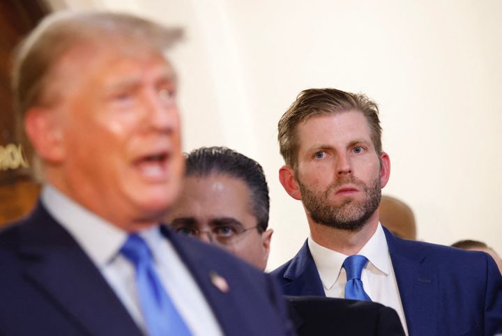 Eric Trump looks on as former President Donald Trump talks to members of the media outside the courtroom at the New York State Supreme Court on the first day of his civil fraud trial, in New York City on October 2.