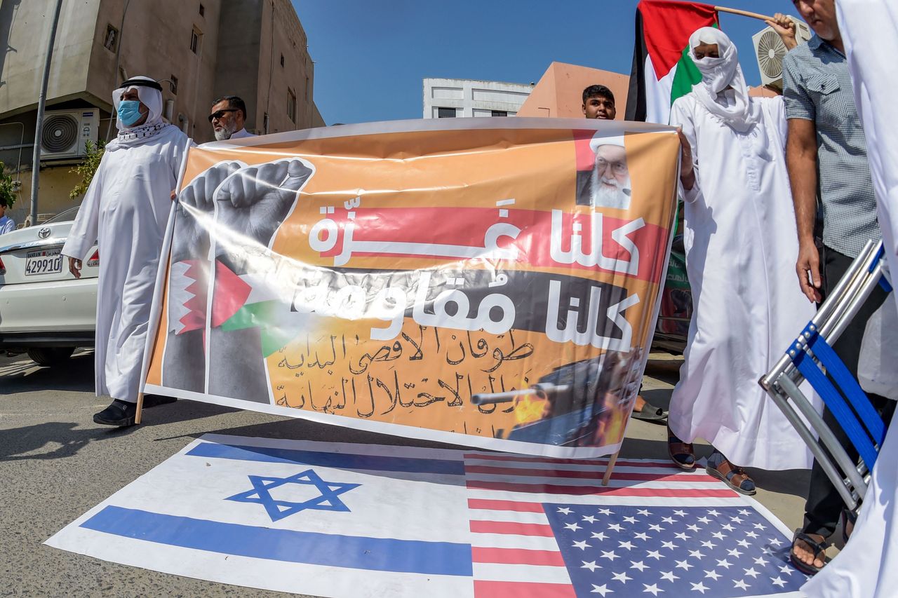 Μπαχραϊνίτες κρατούν πανό και ανεμίζουν παλαιστινιακές σημαίες κατά τη διάρκεια διαμαρτυρίας για την υποστήριξη του παλαιστινιακού λαού μετά την προσευχή της Παρασκευής το μεσημέρι στο χωριό Ντιράζ στη βορειοδυτική ακτή του Μπαχρέιν στις 20 Οκτωβρίου 2023,
