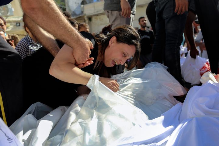 A Palestinian woman mourns over the bodies of her relatives who were killed in Israeli airstrikes that hit a Greek Orthodox church, in Gaza City, on Friday.