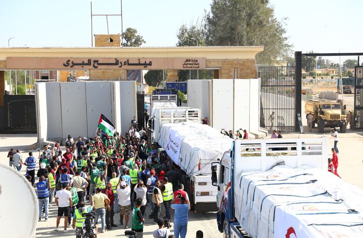 RAFAH, GAZA - OCTOBER 21: First convoy of relief trucks begins to enter the Gaza Strip from the Egyptian side of the Rafah crossing, in Rafah, Gaza on October 21, 2023. This first relief convoy, which comprises a total of 20 trucks, is currently in the process of passing through the Rafah border gate, the Red Crescent said. Humanitarian aid is actively being transferred from Egyptian trucks to Palestinian trucks. (Photo by Stringer/Anadolu via Getty Images)