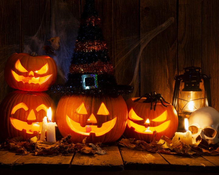 Halloween Jack-o-Lantern Pumpkins on rustic wooden background