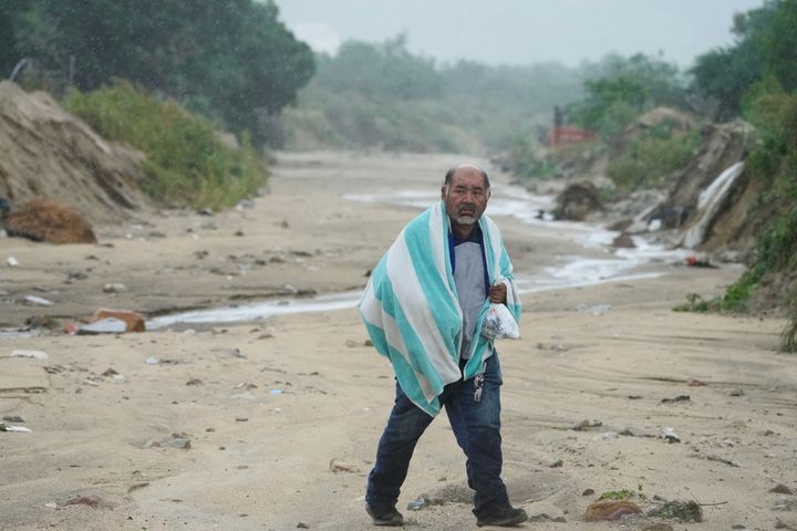 A man walks on the mud caused by hurricane Norma in San Jose del Cabo, Mexico, Saturday, Oct. 21, 2023. (AP Photo/Fernando Llano)