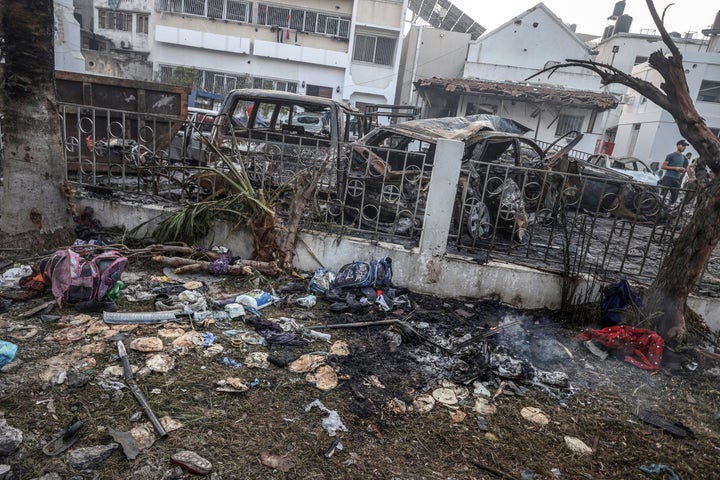 Damaged bags full of clothes are seen as civilians collect usable belongings amid wreckage of vehicles after Al-Ahli Baptist Hospital was hit in Gaza City, Gaza on October 18.