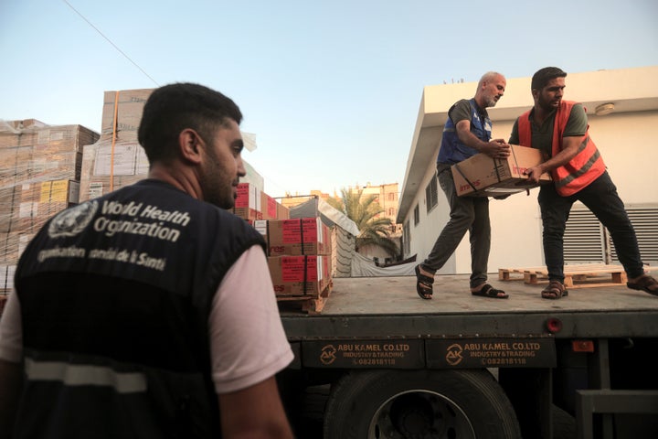 Palestinians unload boxes of medicine from a truck arrived at Nasser Medical Complex, as part of the aid batch that entered into the Gaza strip.