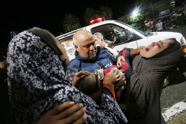 Al Jazeera reporter Wael Dahdouh carries the body of his grandson Wednesday from an ambulance in Gaza City. Dahdouh's wife and children were also killed in an Israeli airstrike, Al Jazeera television, based in Qatar, said.