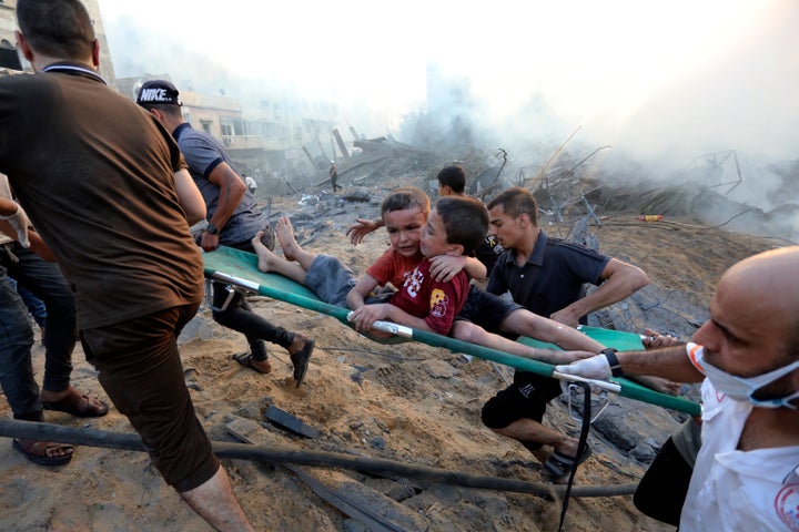 Palestinians evacuate two wounded boys out of the destruction following Israeli airstrikes on Gaza City, on Oct. 25, 2023.