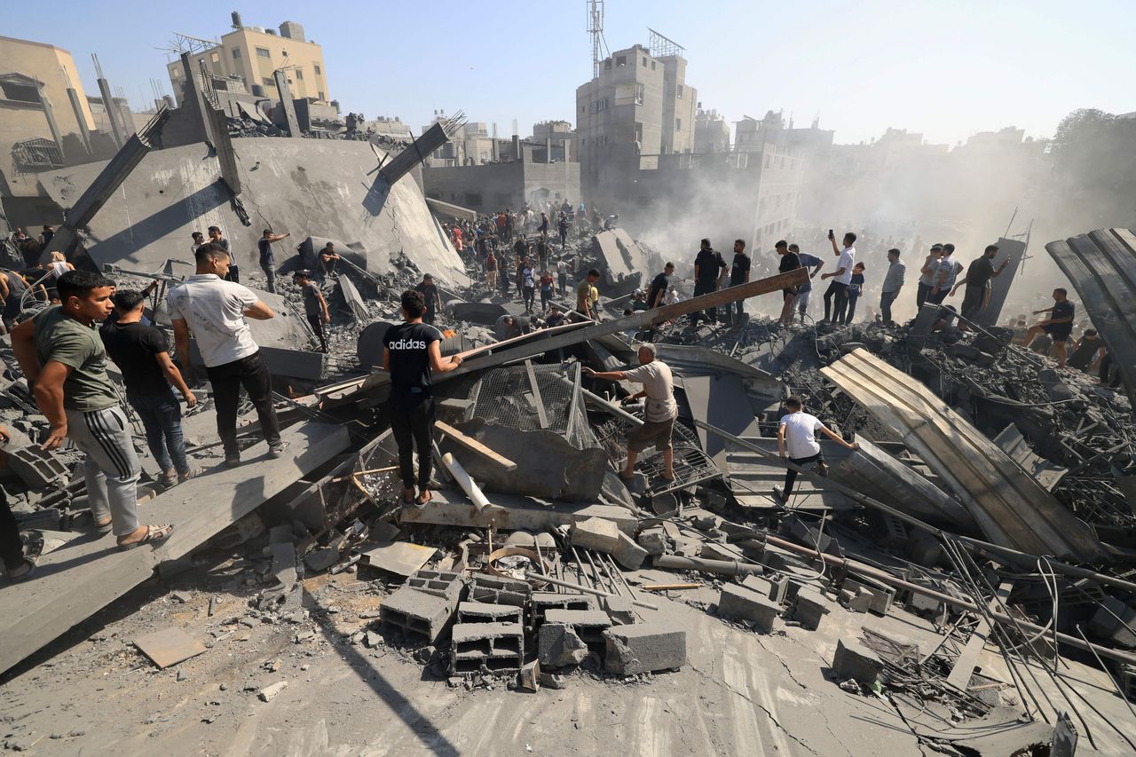 Palestinians search for survivors and the bodies of victims through the rubble of buildings destroyed during Israeli bombardment, in Khan Yunis in the southern Gaza Strip.
