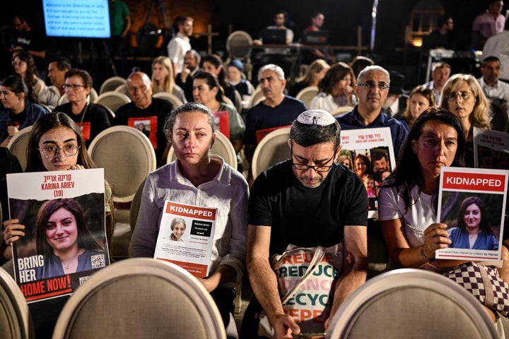 Des gens brandissent des affiches avec des images de l'otage Karina Ariev alors qu'ils se rassemblent sur un endroit surplombant la place du Mur Occidental, le 25 octobre.