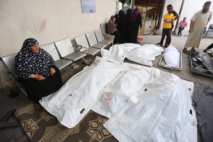Palestinians stand around the bodies of people killed in Israeli bombardment on the Gaza Strip, outside a morgue in Rafah, Friday, Oct. 27, 2023. (AP Photo/Hatem Ali)