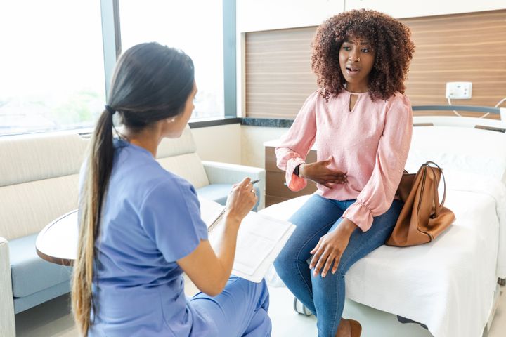 A mid adult woman speaks with a female healthcare professional.