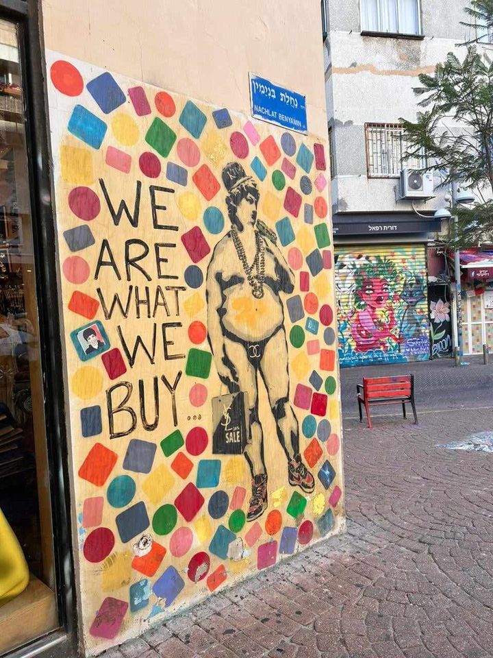Τελ Αβίβ Γκράφιτι σε τοίχο στο Τελ - Αβιβ, με στοιχεία αυτογνωσίας "Είμαστε αυτό που αγοράζουμ