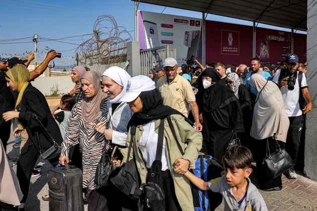 People walk through a gate to enter the Rafah border crossing to Egypt in the southern Gaza Strip on November 1, 2023.