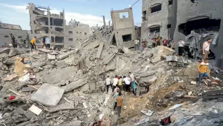 A screen grab captured from a video shared online shows people conducting search and rescue operation under the debris of a destroyed building in Gaza.