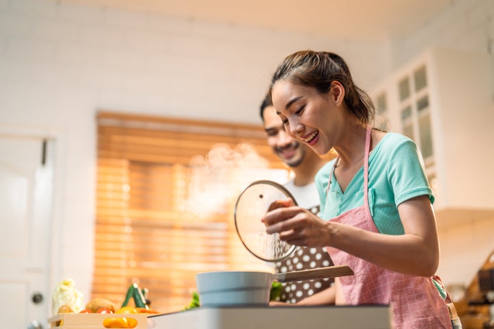 Young couple spend time together in kitchen at home. 