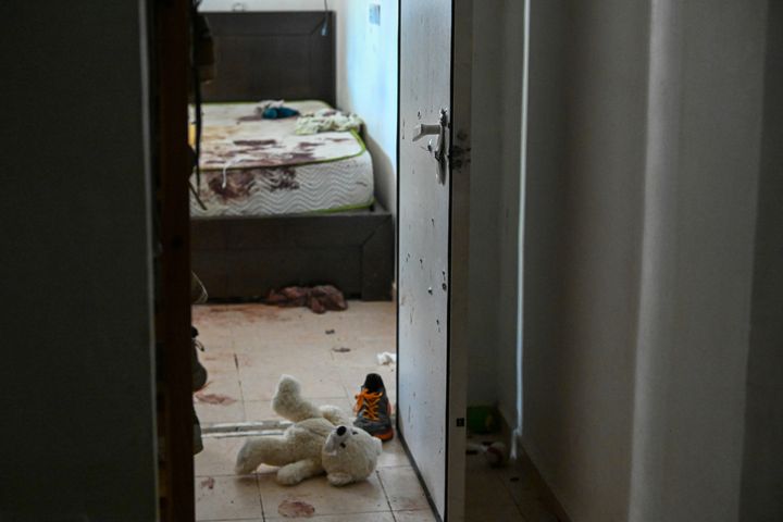 A teddy bear is left on the ground near bloodstains where Israeli Defense Forces say two grandparents held a bomb shelter door closed to protect their grandchildren during an Oct. 7 Hamas attack on this kibbutz in Holit, Israel. All were injured, but survived. More than three weeks since Hamas' attacks in Israel, which killed 1,400 people according to Israeli authorities, just over half of the dead have been laid to rest, and more than four-fifths have been identified.