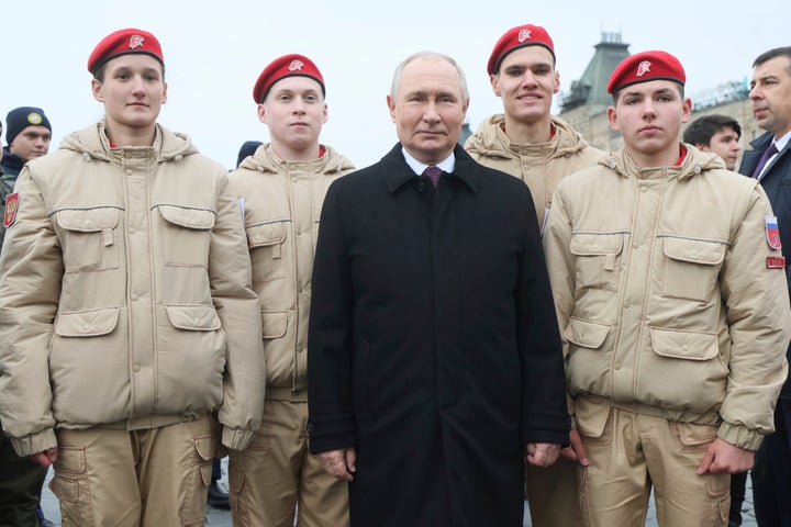 Russian President Vladimir Putin, center, poses for a photo with Members of Russia's Young Army Cadets National Movement members and children of fallen heroes of the military operation in Ukraine, after a flower-laying ceremony at the monument of Minin and Pozharsky at Red Square in Moscow on Saturday, Nov. 4.