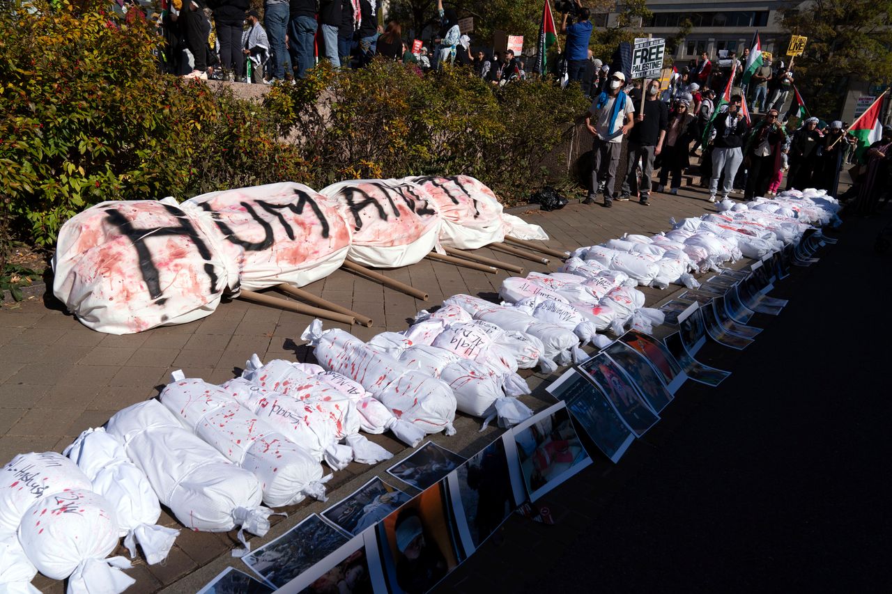 White sack representing the bodies of people killed in Gaza lay on the ground.