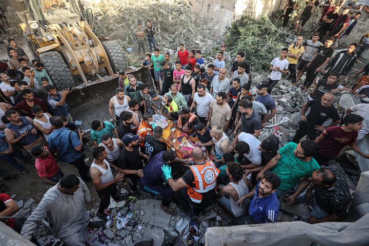 KHAN YUNIS, GAZA - NOVEMBER 04: Rescuers pull out a body from under the rubble after an Israeli attack hits en-Neccar family apartment in Khan Yunis, Gaza on November 04, 2023. (Photo by Mustafa Hassona/Anadolu via Getty Images)