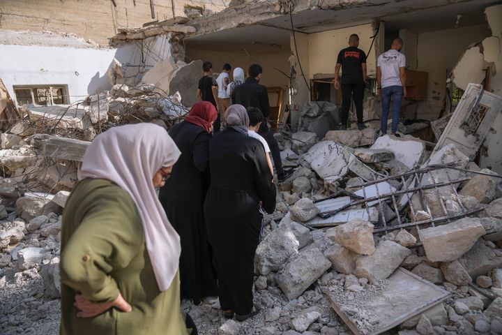 Palestinians inspect a damaged house that was raided by the Israeli army in the West Bank town of Abu Dis, Sunday, Nov. 5, 2023. The military said that the house was home to a militant who had orchestrated attacks against Israeli forces, the 22-year-old Palestinian was shot and killed during the raid. (AP Photo/Mahmoud Illean)