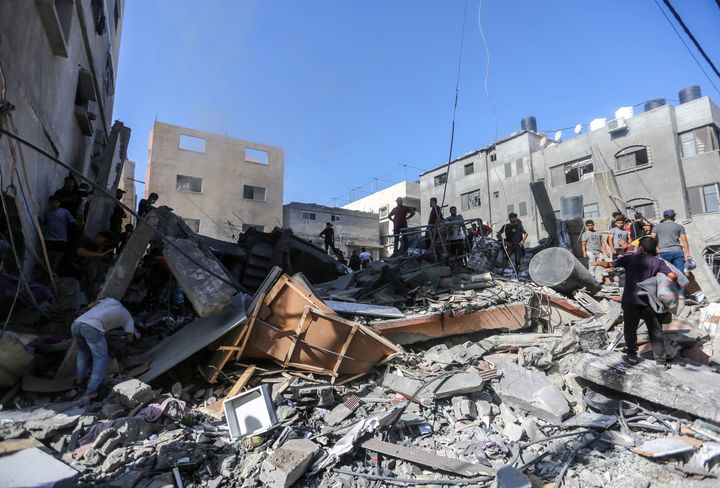 People search through buildings, destroyed during Israeli air raids in the southern Gaza Strip on November 6, 2023
