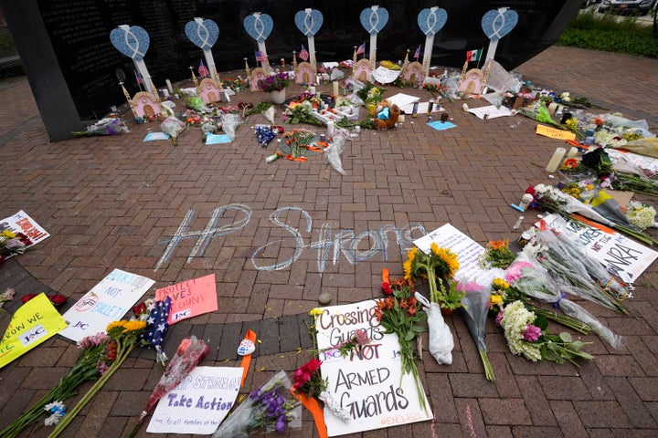 Mourners left flowers and signs at a memorial to the seven people killed and dozens of others injured in the Highland Park shooting on July 4, 2022.