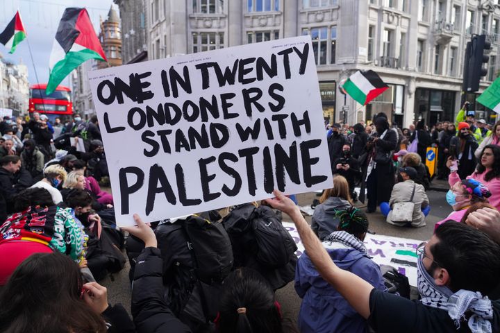 Protestors stage a temporary sit-in in Oxford Circus, blocking all traffic as tens of thousands of pro-Palestine demonstrators gathered to demand an immediate ceasefire of the Israel - Hamas war.