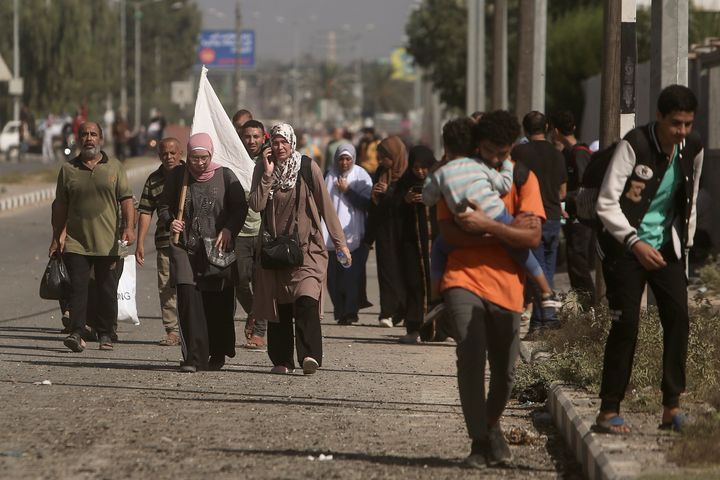 A woman carries a white flag to prevent being shot, as Palestinians flee Gaza City to the southern Gaza Strip on Salah al-Din street in Bureij, on Nov. 7, 2023. 