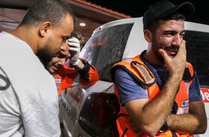 Palestinian paramedics cry outside Al-Shifa hopsital in Gaza City on October 16, 2023.