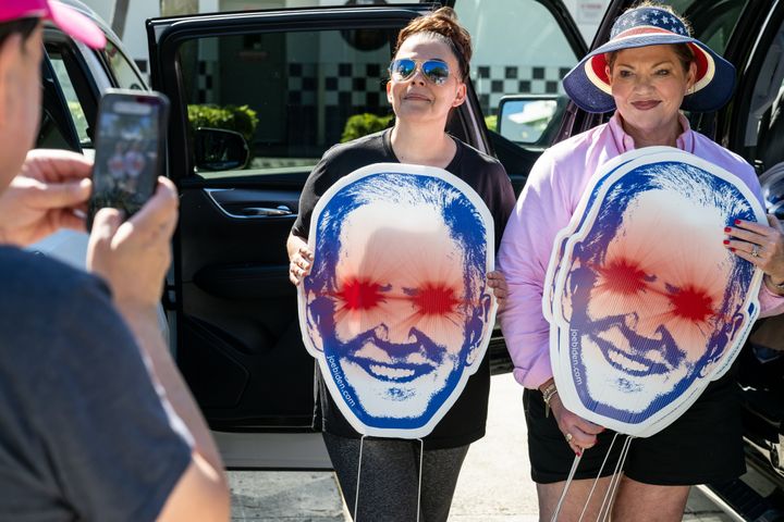 Supporters of President Joe Biden display "Dark Brandon" signs ahead of the third Republican debate in Miami on Wednesday.