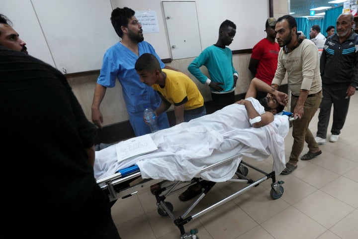 Palestinians wounded in the Israeli bombardment of the Gaza Strip are brought to a treatment room of al Aqsa Hospital on Deir al Balah, Gaza Strip, Friday, Nov. 10, 2023. (AP Photo/Adel Hana)