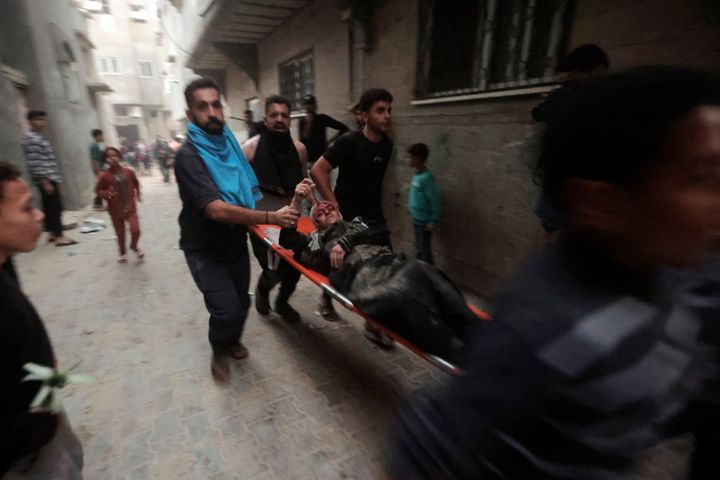 Palestinians evacuate a wounded woman following an Israeli airstrike in Khan Younis refugee camp, southern Gaza Strip, Monday, Nov. 13, 2023. (AP Photo/Mohammed Dahman)
