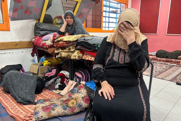 Umm Ibrahim Alayan, who is eight-months-pregnant, covers her face as she reacts at a United Nations Relief and Works Agency for Palestine Refugees in the Near East (UNRWA) school in Rafah in the southern Gaza Strip, on November 10, 2023.