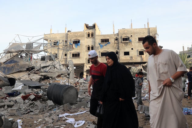 People walk amid the destruction following Israeli bombing on Rafah in the southern Gaza Strip.