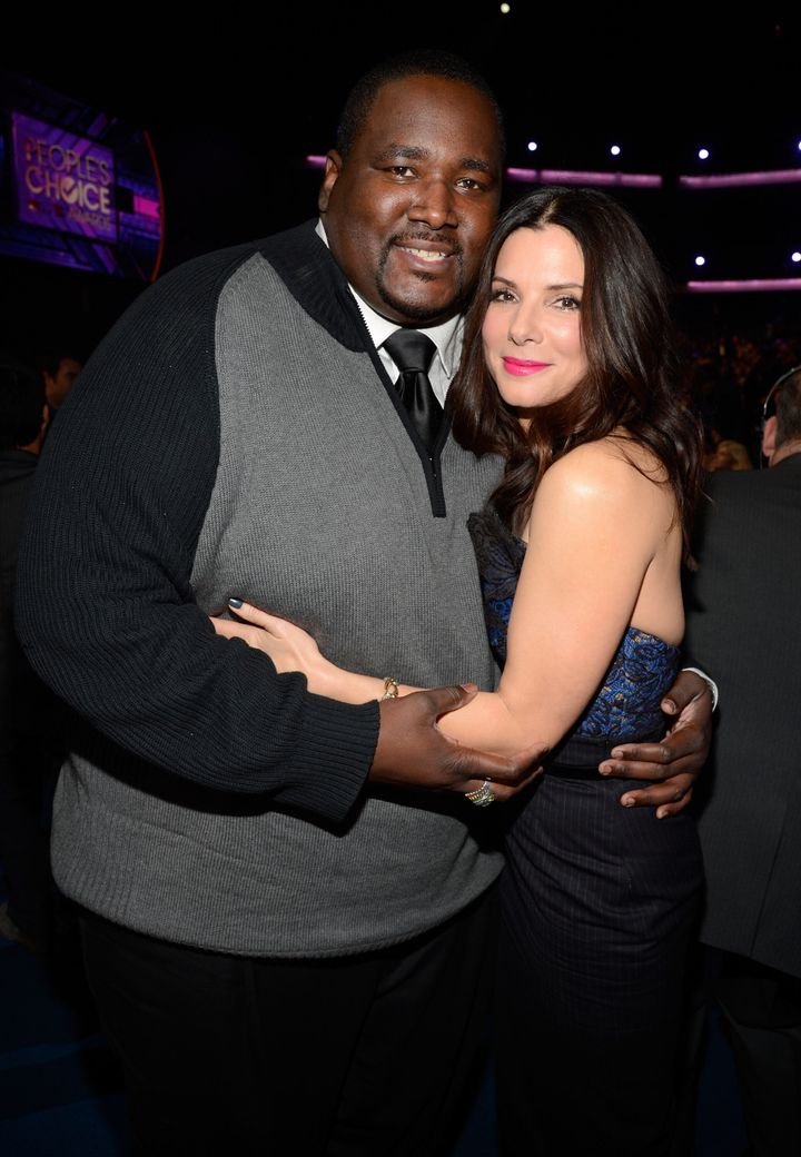 Actor Quinton Aaron, who portrayed Michael Oher in the 2009 film, with co-star Sandra Bullock in 2013.