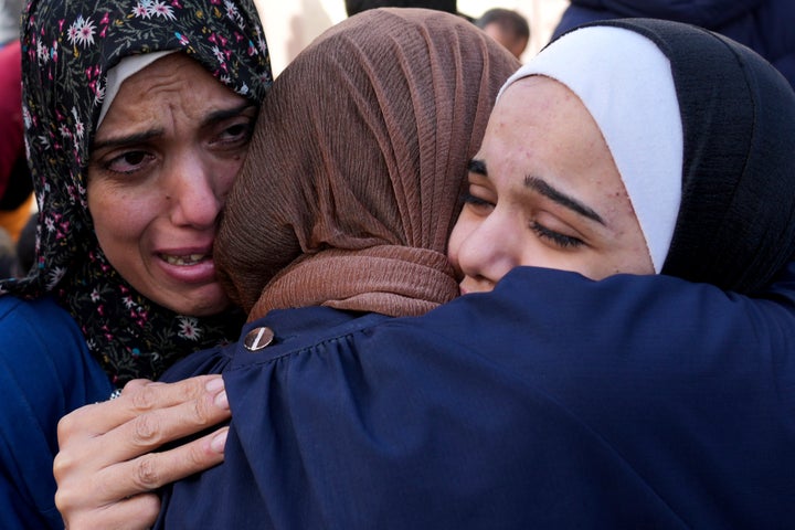 Palestinians mourn relatives killed in the Israeli bombardment of the Gaza Strip in front of the morgue in Deir al Balah, Sunday, Nov. 19, 2023.