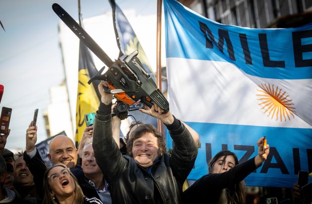 Javier Milei lifts a chainsaw next on the campaign trail in September