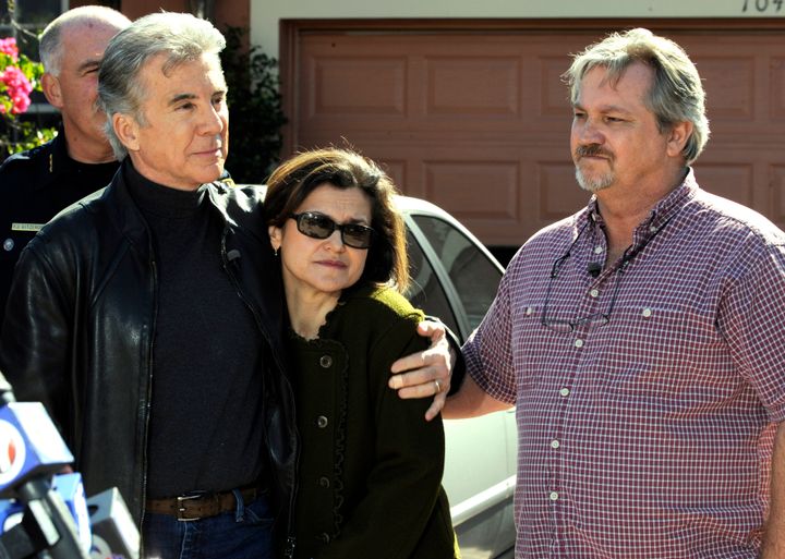 "America's Most Wanted" host John Walsh (left) hugs Muriel Sitton as her husband, Jim Sitton, looks on during a segment of the TV show at the Sittons' home. Muriel Sitton's cousin, Paul Michael Merhige, had been in hiding since shooting four relatives on Thanksgiving night.