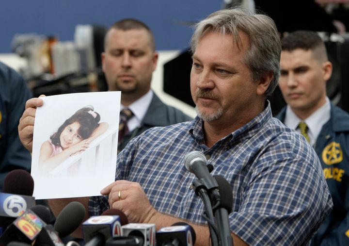 Jim Sitton holds up a photograph of his 6-year-old daughter Mikayla during a news conference about an international manhunt for Paul Merhige in Miami Beach, Florida, on Dec. 22, 2009. Sitton's daughter was one of the four victims.