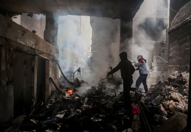 Palestinians try to put out the fire in their house after Israeli planes bombed it in the city of Khan Yunis, south of the Gaza Strip.