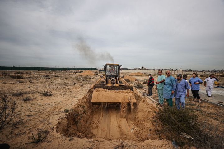 A construction machine digs a mass grave for 111 Palestinians, who lost their lives during the Israeli attacks, to bury them in the cemetery in Khan Yunis, Gaza on November 22, 2023.