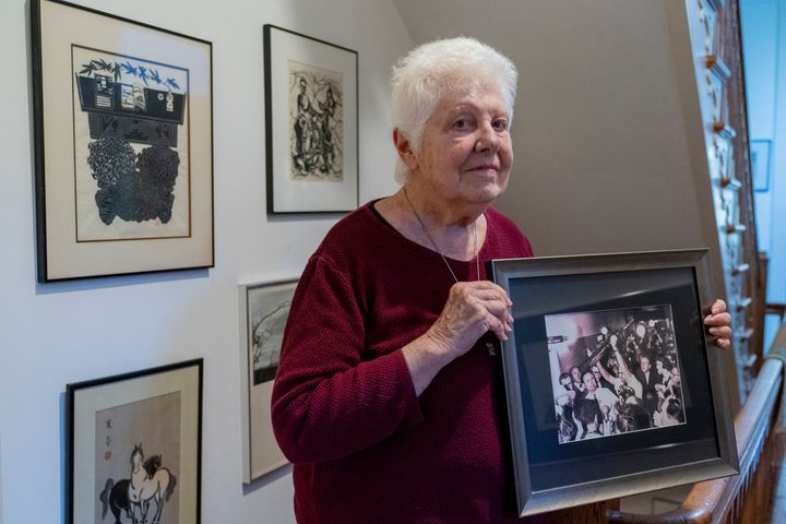 Peggy Simpson holds a photograph of law enforcement carrying Lee Harvey Oswald's gun through a hallway packed with reporters, on Nov. 17, 2023, at her home in Washington. Simpson, a former Associated Press reporter, is among the last surviving witnesses to the events surrounding the assassination of Kennedy are among those sharing their stories as the nation marks the 60th anniversary. 
