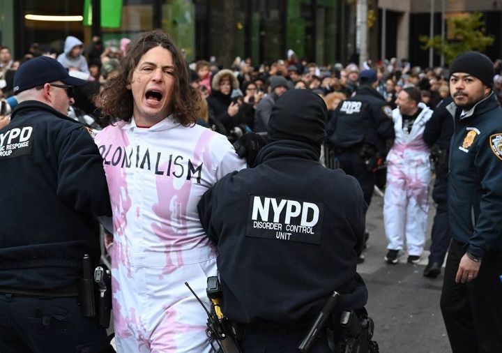 The demonstrators wore jumpsuits with the words “colonialism,” “racism,” “militarism” and “ethnic cleansing” on them.