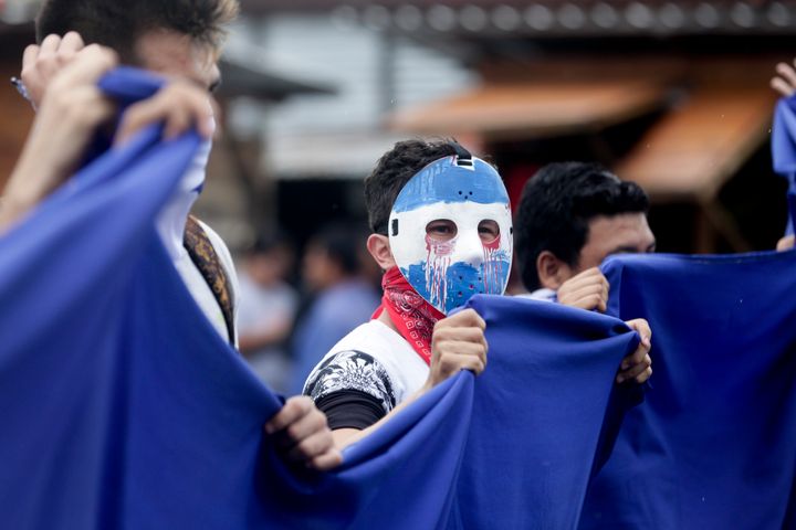 A masked demonstrator attends a protest outside the Jesuit run Universidad Centroamericana, UCA, demanding the university's allocation of its share of 6% of the national budget, in Managua, Nicaragua, Thursday, Aug. 2, 2018. (AP Photo/Arnulfo Franco)