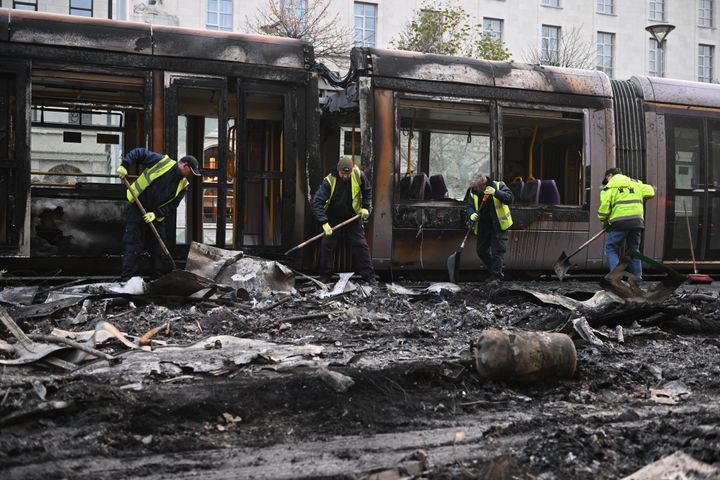 Workers clean up the debris of a burnt train on Nov. 24, 2023, in Dublin, Ireland.