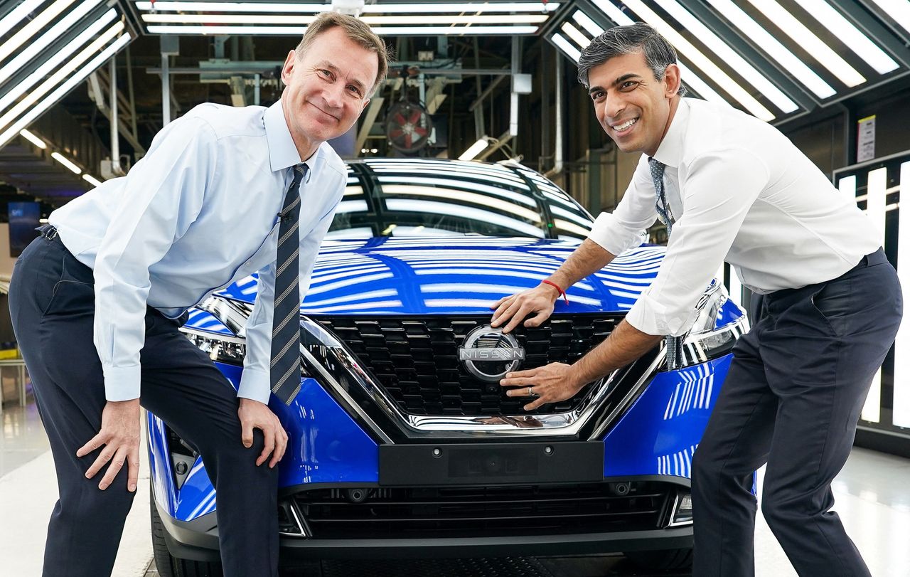 Rishi Sunak and Jeremy Hunt attach a Nissan badge to the grill of a newly manufactured car at the Nissan production plant in Sunderland yesterday.